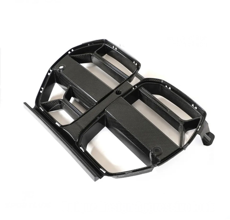 A black carbon fiber car grille, featuring multiple openings and a sleek design, rests on a plain white background.