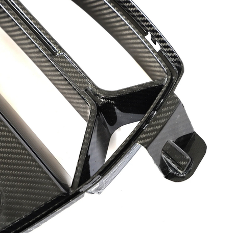 Carbon fiber car part, featuring a sleek, angular design with precise edges, lies on a smooth surface, highlighting its glossy, patterned finish and craftsmanship.