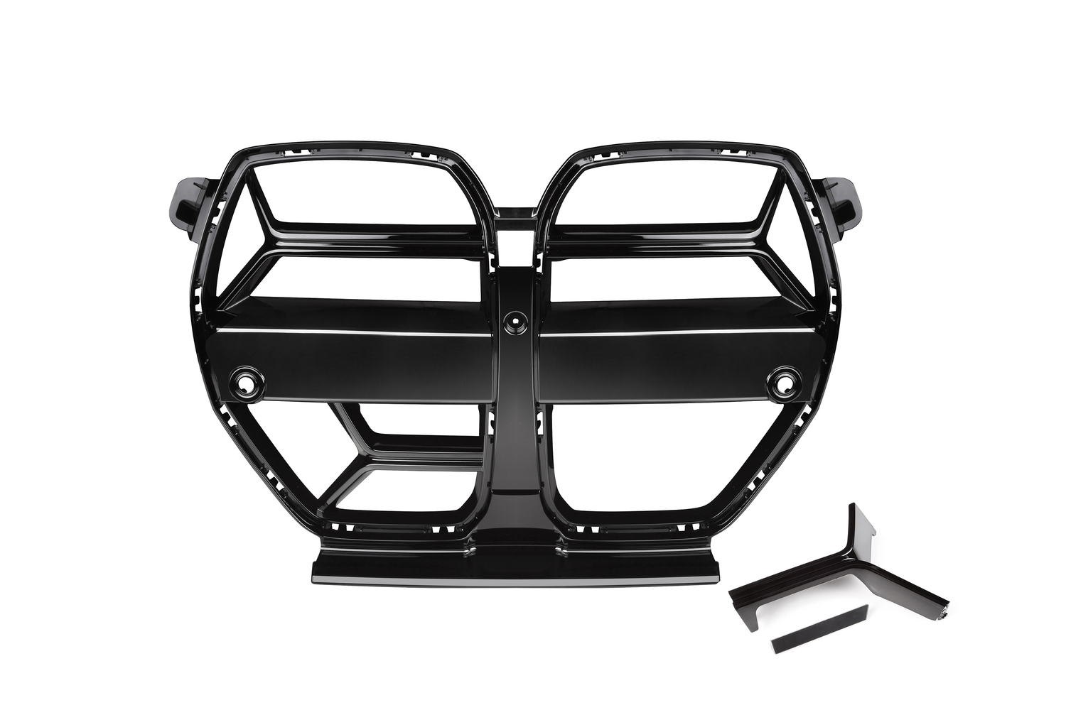 A glossy black car grille with a segmented design rests on a white background, featuring dual openings and two separate black trim pieces nearby.