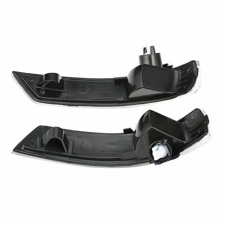 Two black car mirror indicators, each with a sleek curved shape and mounting clips, lie against a white background, showcasing their design and structure for automotive use.