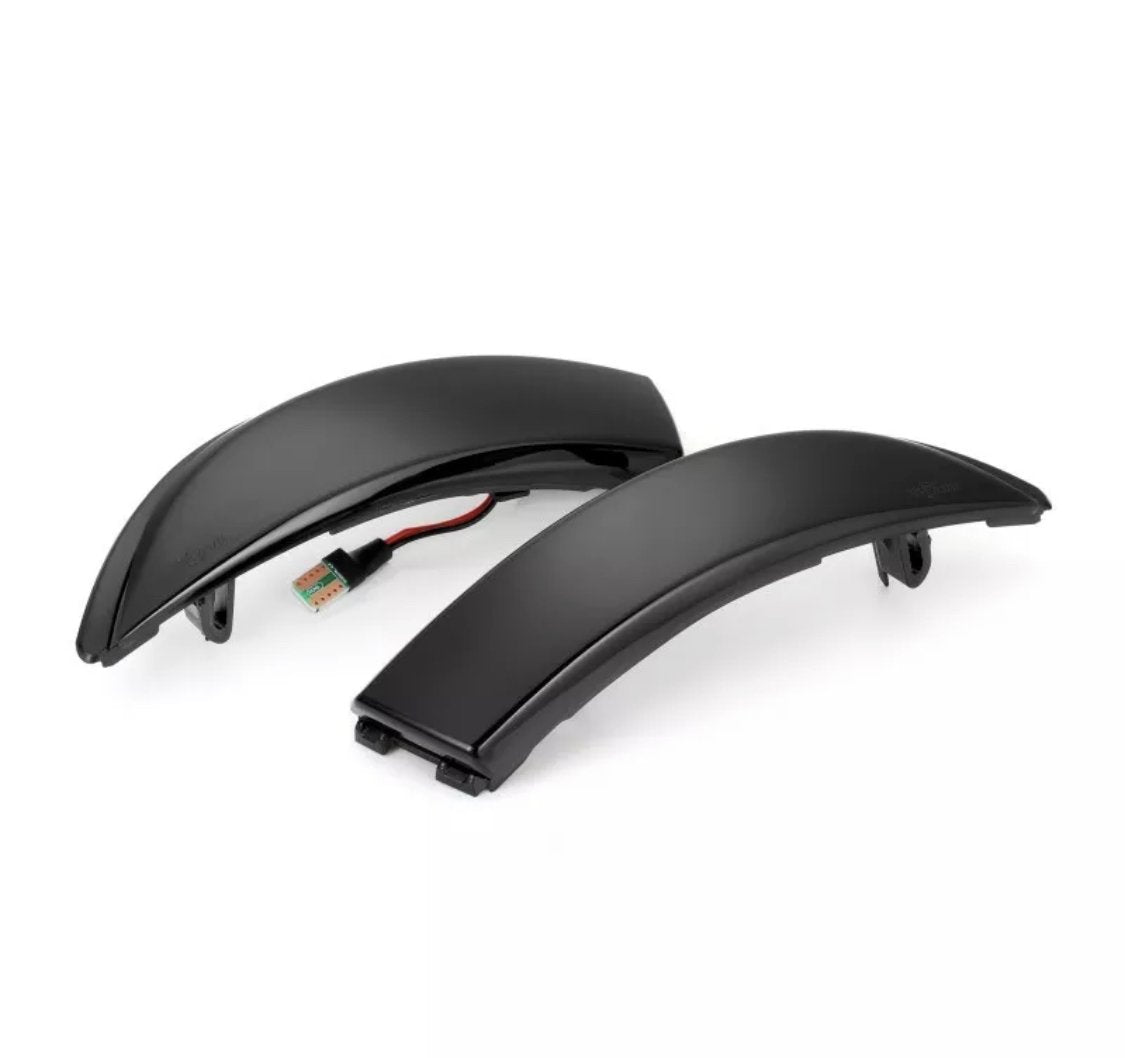 Two black curved LED indicator lights rest on a white background, each featuring a connected wire and plug, designed for automotive or motorcycle use as signal lights.