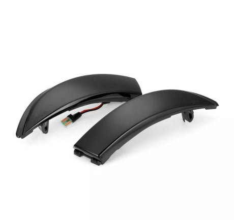 Two black curved LED indicator lights rest on a white background, each featuring a connected wire and plug, designed for automotive or motorcycle use as signal lights.