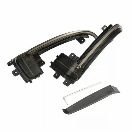 Curved, black plastic automotive parts with mounting brackets sit on a white background. A thin metal rod and a separate flat black piece accompany the main components, suggesting car accessory assembly.