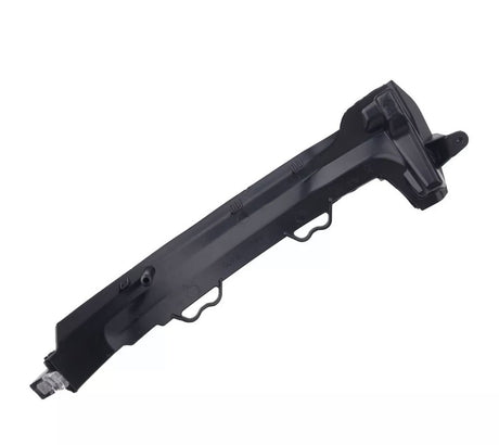 A black, angular plastic car component with multiple ridges and mounting points, possibly a bumper bracket, rests against a plain, white background.