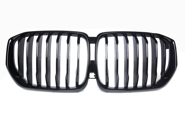 A shiny black car grille with vertical slats, forming two adjacent kidney-shaped sections, set against a plain white background.
