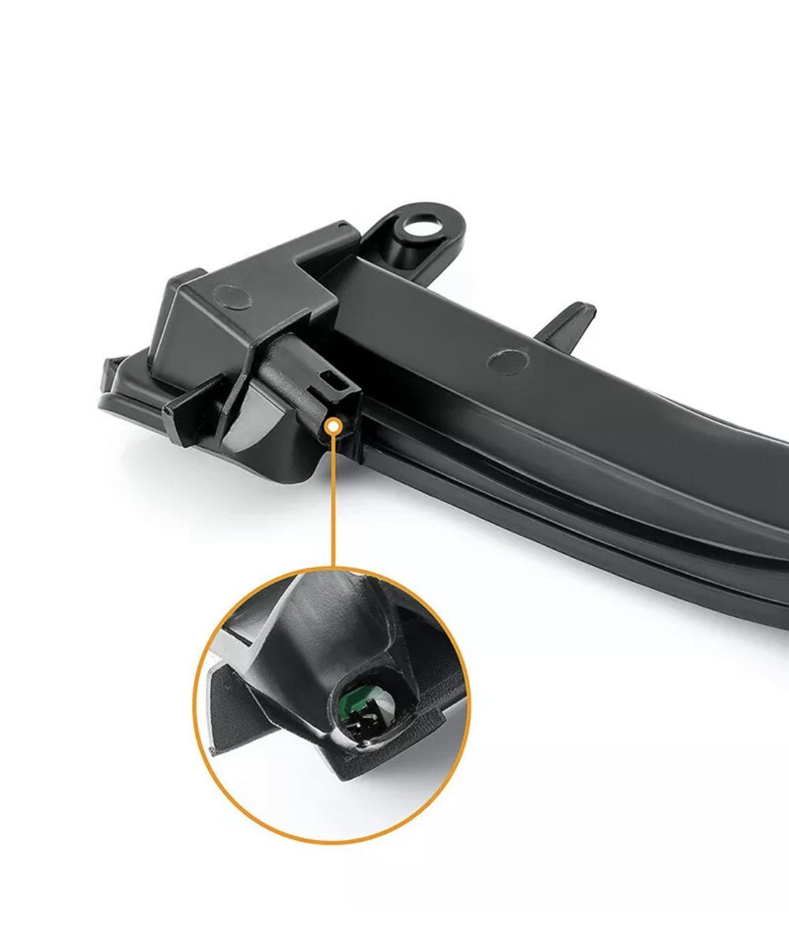 A black plastic car part is highlighted with a circular magnification, showing a small green component. It is against a plain white background.