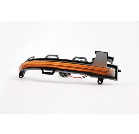 A curved, amber-colored car indicator light with plastic mounting brackets rests on a white background, featuring attached wiring for electrical connection.