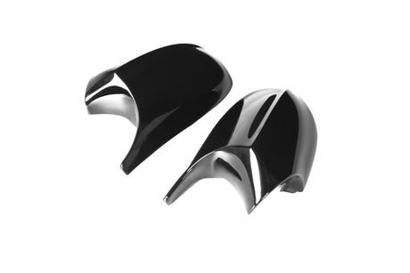 Two black, glossy car mirror covers, lying side by side, are positioned on a plain white background.