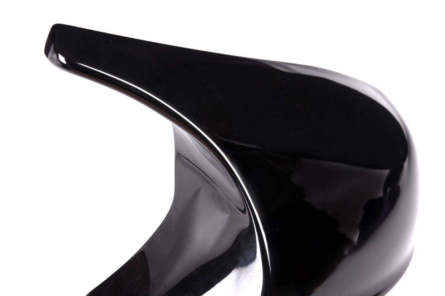 A glossy black high-heeled shoe with a dramatic curved arch stands against a plain white background, highlighting its sleek, artistic design.
