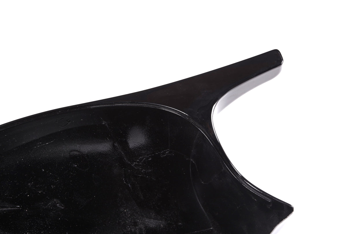 A glossy black spatula-like object with an elongated handle is shown in close-up against a plain white background.