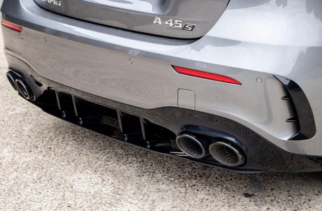 Car rear displays dual exhaust pipes and "A 45 S" badge, parked on concrete. The grey exterior includes a black diffuser and subtle red accents under a bright sky.