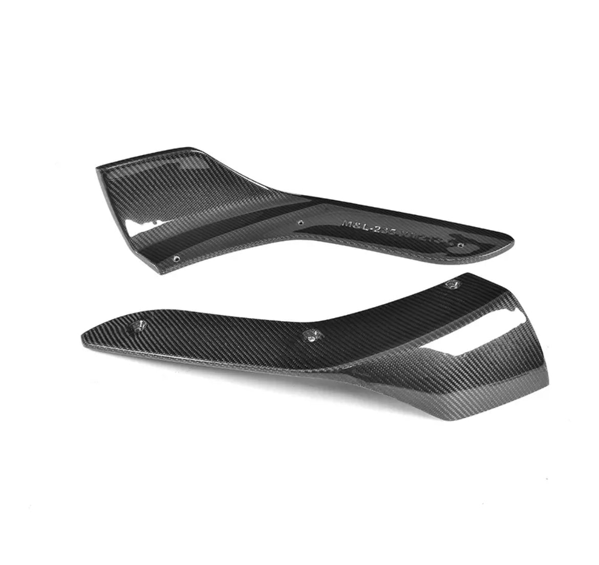 Two black carbon fiber automotive parts are placed on a white background. Text on one part reads "M&L-235-V1R7-2". Both parts have a sleek, aerodynamic design with mounting holes.