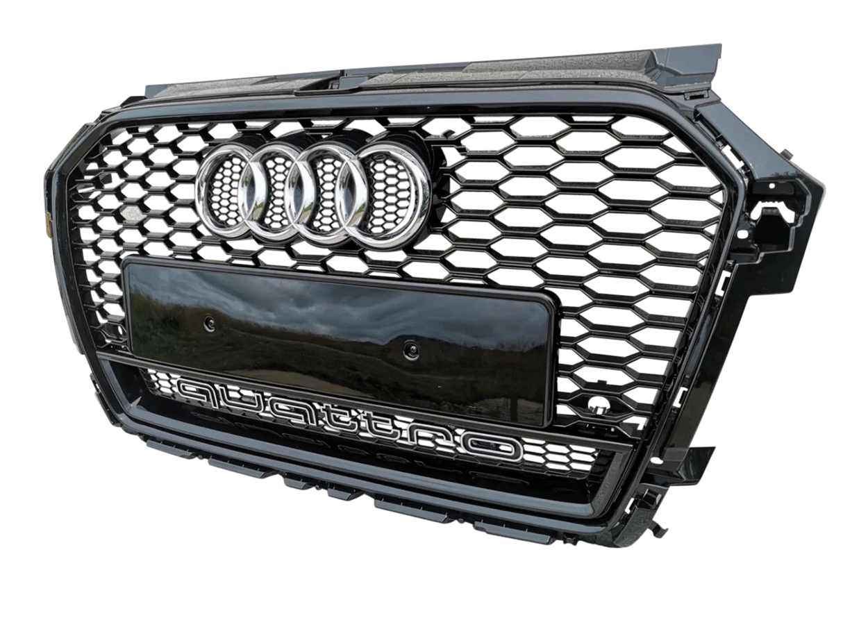 A black car grille with a honeycomb pattern, featuring four chrome rings and "quattro" text, is displayed against a plain background.
