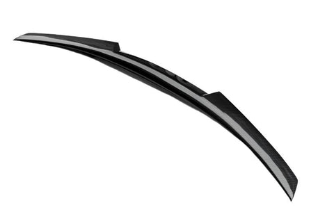 A sleek, curved black spoiler with a carbon fiber texture rests in isolation against a plain white background.