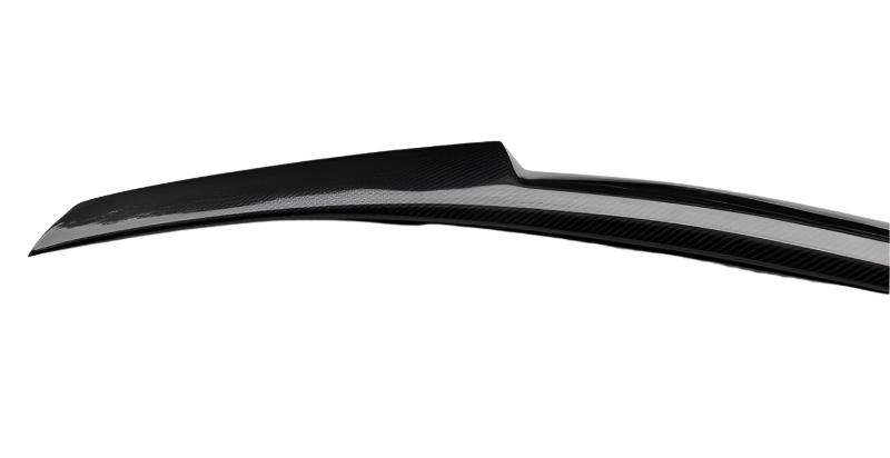 A black carbon fiber car spoiler extends horizontally, designed for aerodynamic efficiency, set against a plain white background.