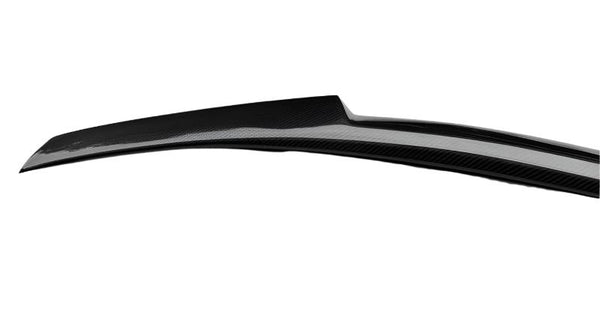 A black carbon fiber car spoiler extends horizontally, designed for aerodynamic efficiency, set against a plain white background.