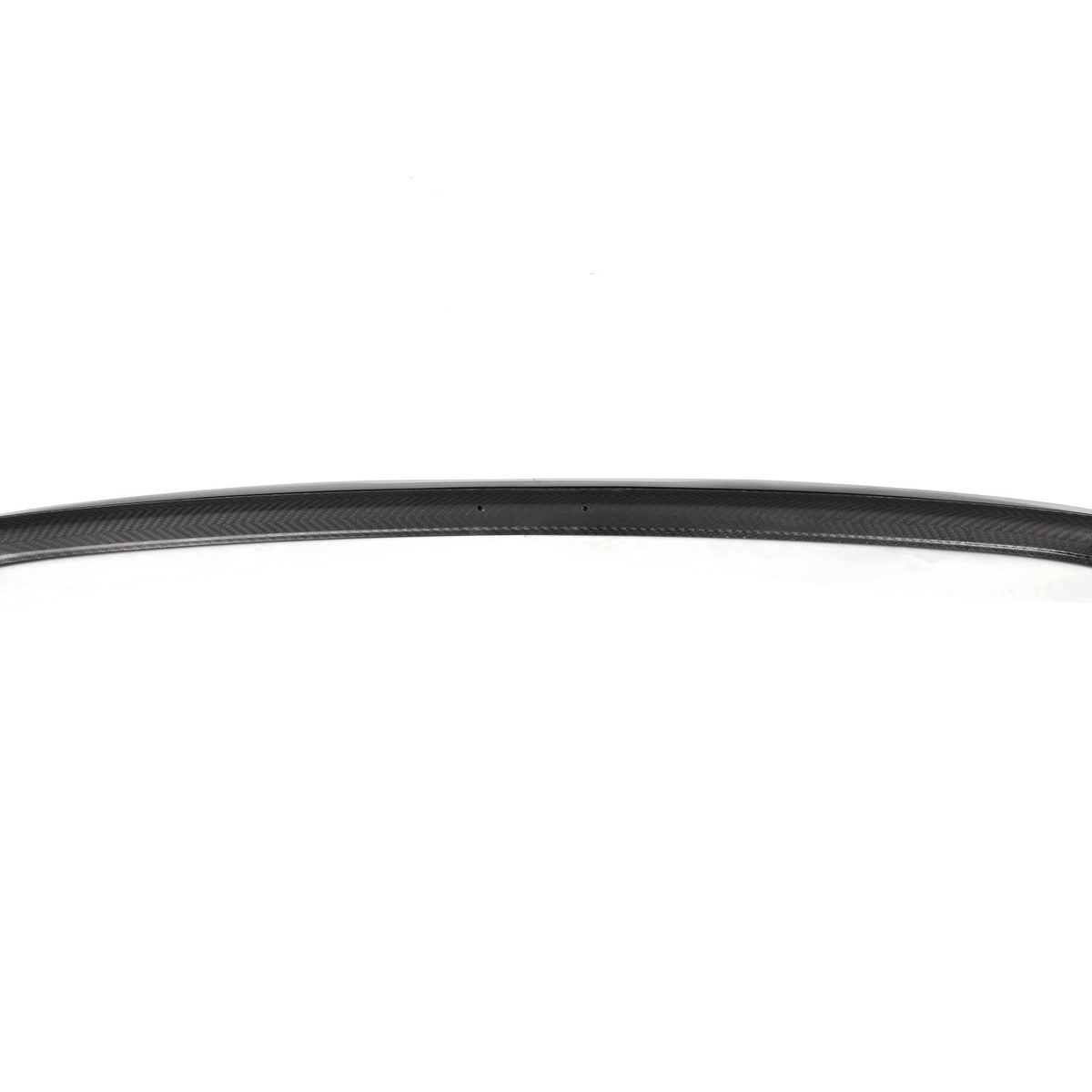 A curved, black carbon fiber car spoiler rests on a white background, displaying a smooth, textured pattern and a small label on the right side.
