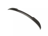The object is a carbon fiber car spoiler, slightly curved, positioned against a plain white background.