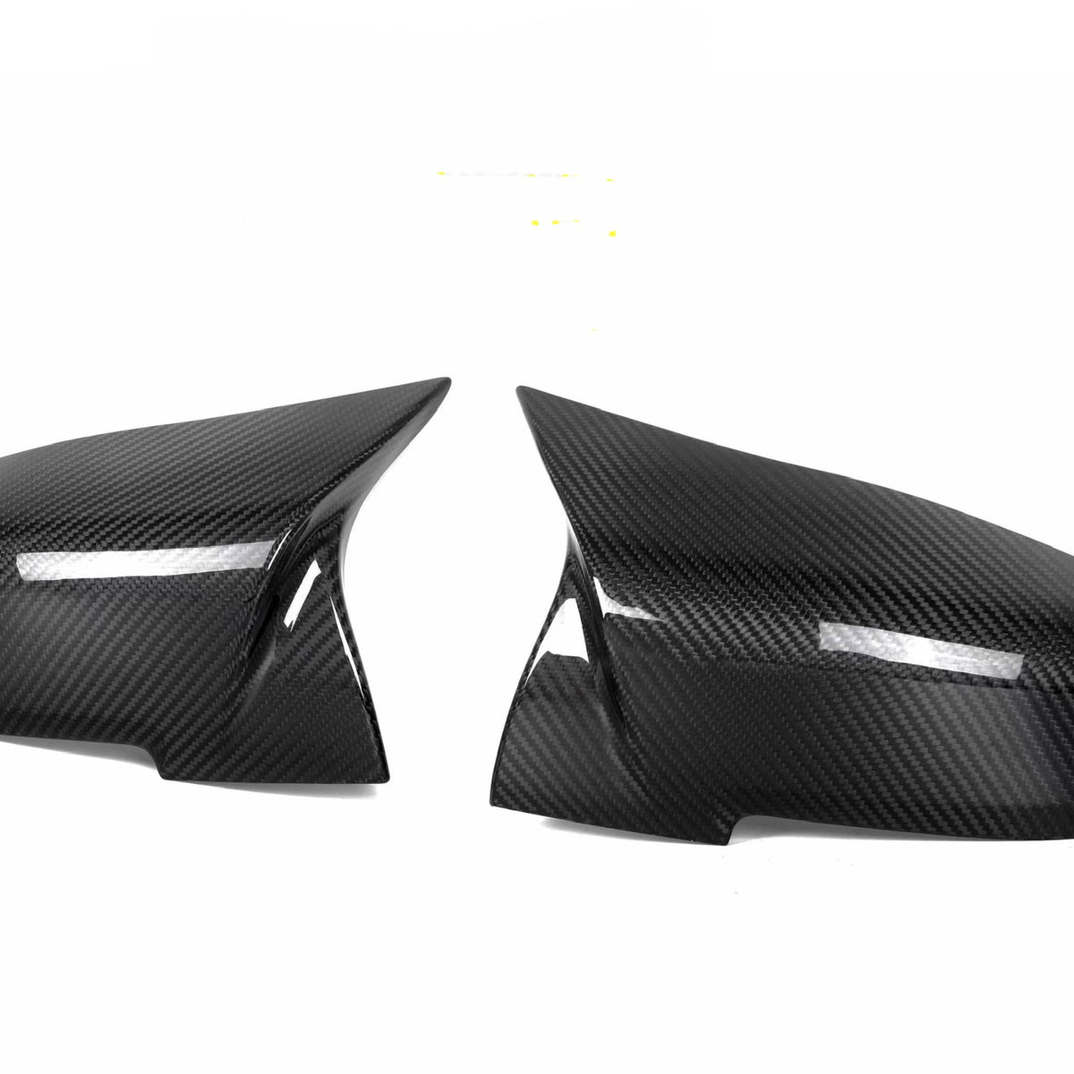 Carbon fiber mirror covers facing each other, glossy finish reflecting light, against a plain white background.
