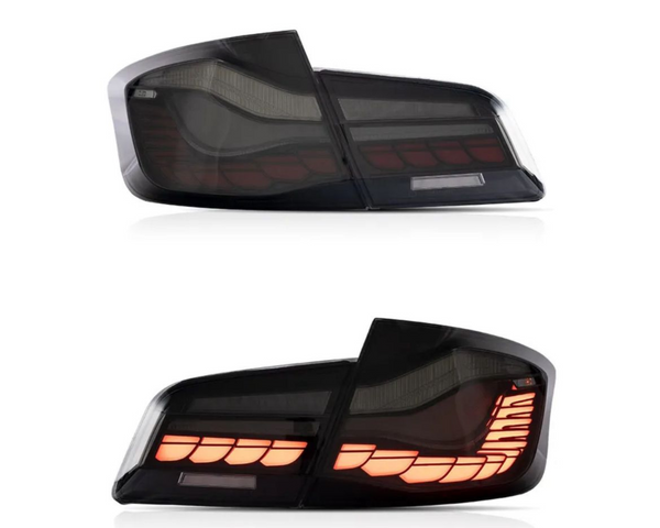 Two car taillights are shown. The top taillight is unlit, while the bottom taillight is illuminated with a segmented amber light pattern, on a plain white background.