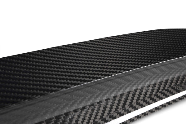 A sleek carbon fiber sheet displaying a distinctive woven pattern; it sits on a plain white background, emphasizing its glossy texture and modern aesthetic.