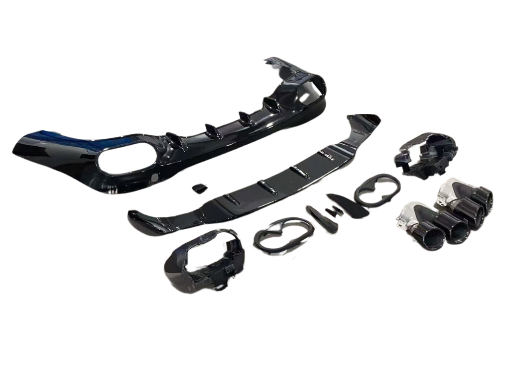 A set of glossy black automotive parts, including bumper sections and exhaust tips, is laid out methodically against a white background, suggesting vehicle assembly or modification.