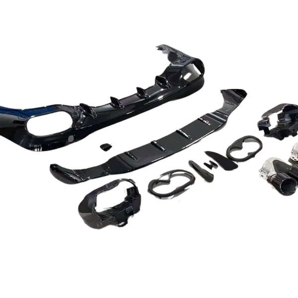 A set of glossy black automotive parts, including bumper sections and exhaust tips, is laid out methodically against a white background, suggesting vehicle assembly or modification.