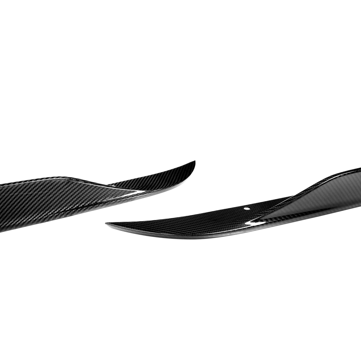 Two glossy, black carbon fiber side skirts with a slight upward curve rest on a white background, showcasing aerodynamic enhancements for vehicles.