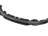 A black carbon fiber car front splitter with several attachment points lies against a plain white background. Text on the splitter reads 