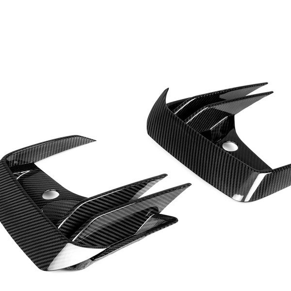 Carbon fiber car parts featuring sharp, angular fins and glossy finish; positioned against a plain white background, highlighting their sleek design and modern material.