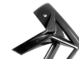 Carbon fiber bike frame features angled, sleek lines with a glossy finish, set in a stark white studio background highlighting its modern, high-performance design.