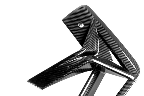 Carbon fiber bike frame features angled, sleek lines with a glossy finish, set in a stark white studio background highlighting its modern, high-performance design.