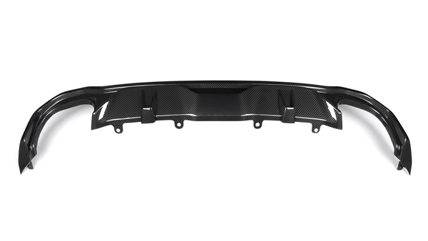 A carbon fiber rear diffuser with multiple fins is positioned horizontally, intended for aerodynamic improvement in a vehicle setting. The background is plain and white.