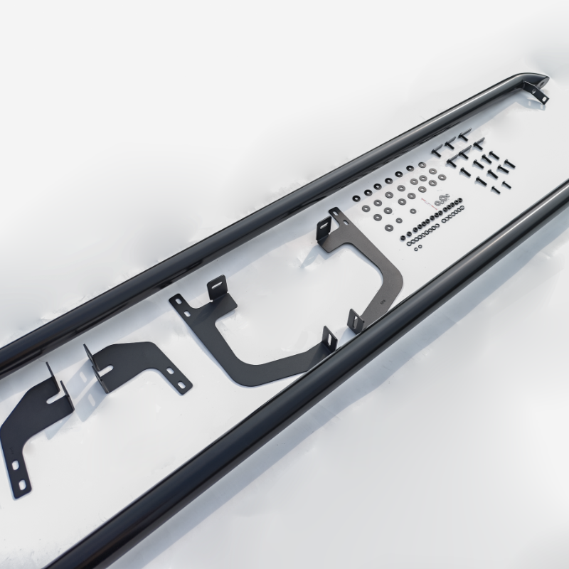 Black metal side step assembly, unassembled, positioned on a white surface with brackets, bolts, and washers lined up methodically, ready for installation.