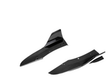 Two black carbon fiber car components are shown, featuring streamlined curves and holes for attachment, set against a plain white background.