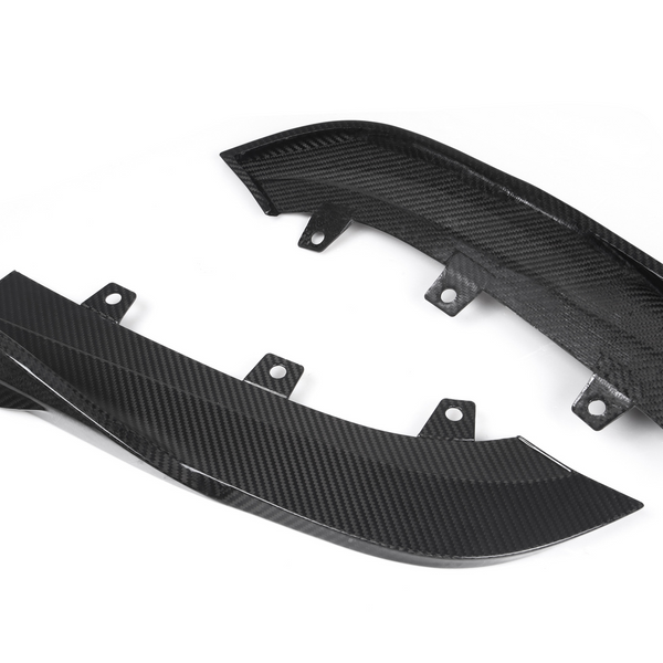 Two carbon fiber car parts with curved designs rest on a white background, featuring multiple mounting points.
