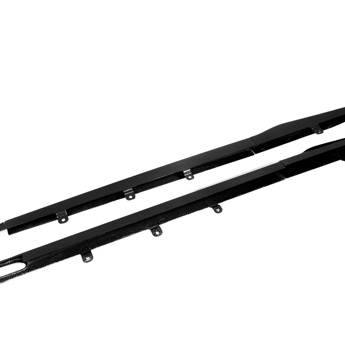 Two black carbon fiber car side skirts with attachment brackets lie against a plain white background, emphasizing their sleek design and aerodynamic purpose.