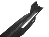 Carbon fiber car part features a sleek, angular design with cutouts and protrusions, set against a plain white background, suggesting high-performance automotive application.