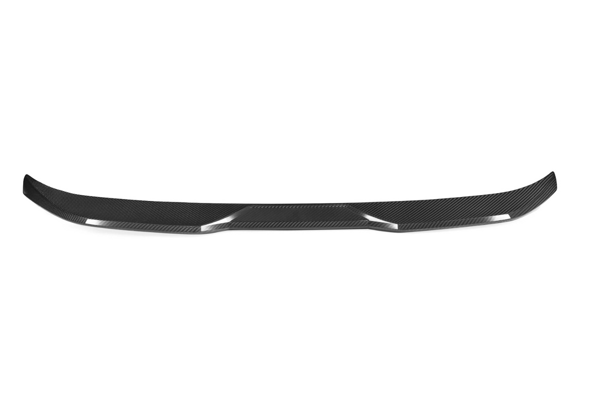 A carbon fiber car spoiler is laid out against a white background, showcasing its sleek, aerodynamic curvature and glossy texture.