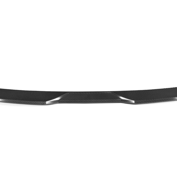 A carbon fiber car spoiler is laid out against a white background, showcasing its sleek, aerodynamic curvature and glossy texture.
