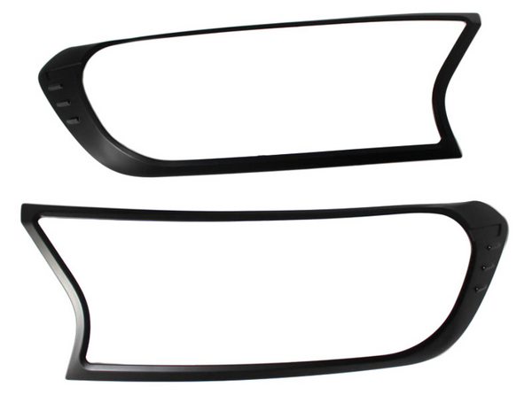 Two black plastic frames, resembling headlight covers, are positioned horizontally against a plain white background. Each frame has an asymmetric, modern design with smooth curves and sharp angles.
