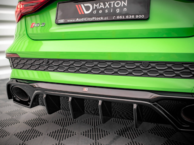 A vibrant green car rear shows a black-edged bumper and diffuser with a "Maxton design" license plate. Context: parked on a patterned surface. Text: "AudiCityPłock.pl," "661 636 900," "RS 3."