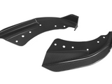 Two black carbon fiber automotive winglets with multiple circular cutouts rest against a white background, showcasing a sleek, aerodynamic design.