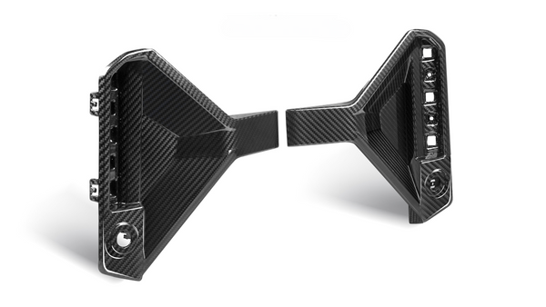 Two black carbon fiber car parts with angular designs are positioned facing each other. The left piece has visible attachment points; the right features an array of cutouts.