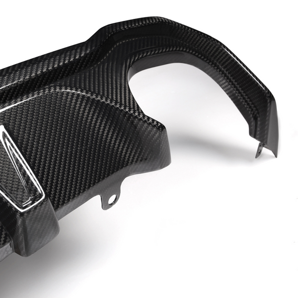 A carbon fiber car part with angled attachments lies on a plain white background, showcasing its textured surface and precision design.