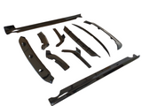 Black glossy car body kit parts are arranged on a plain white background. They vary in shape and size, including side skirts, bumpers, and fenders, showcasing their aerodynamic design.