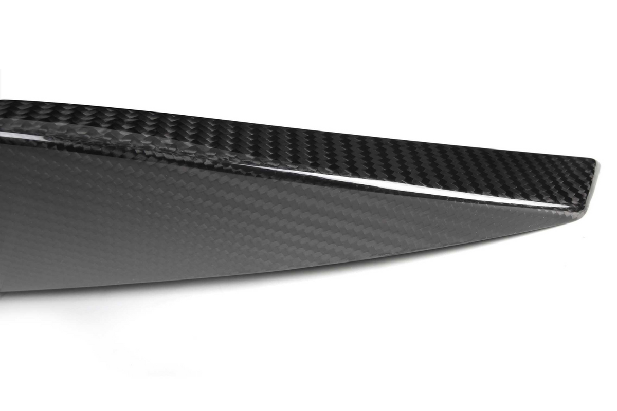 A sleek, black carbon fiber piece with a glossy finish; it has a pointed edge and diagonal patterning, set against a plain white background.