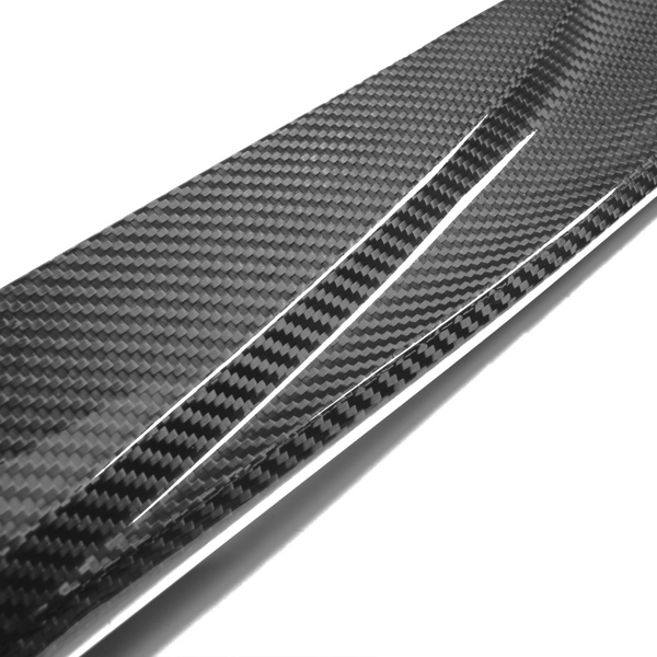 A shiny carbon fiber strip with a textured, checkered pattern is angled diagonally, reflecting light against a plain white background.