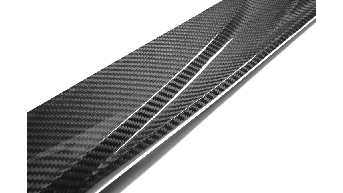 A shiny carbon fiber strip with a textured, checkered pattern is angled diagonally, reflecting light against a plain white background.