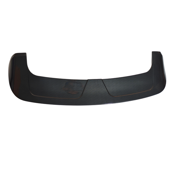 Carbon fiber car spoiler resting on a white background, featuring a curved design with textured surface and angular ends, suggesting an aerodynamic function.